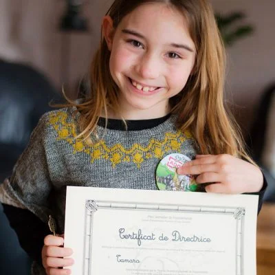 Petite fille avec un certificat de directrice et un badge d'Epopia